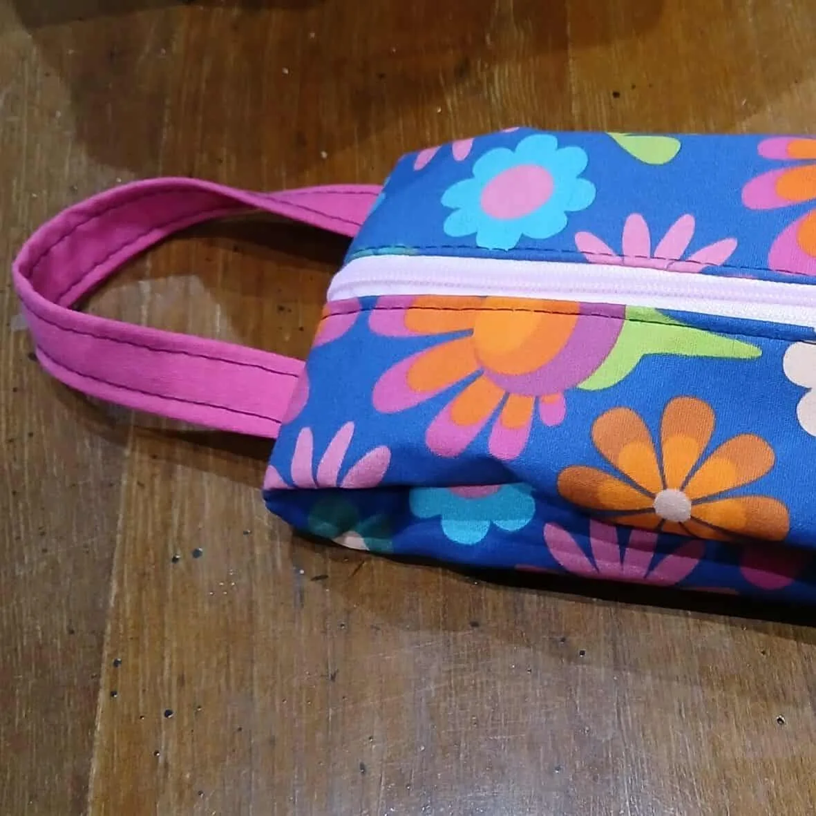 Gros plan sur la fermeture éclair et l'anse de la trousse en tissu imprimé fait main