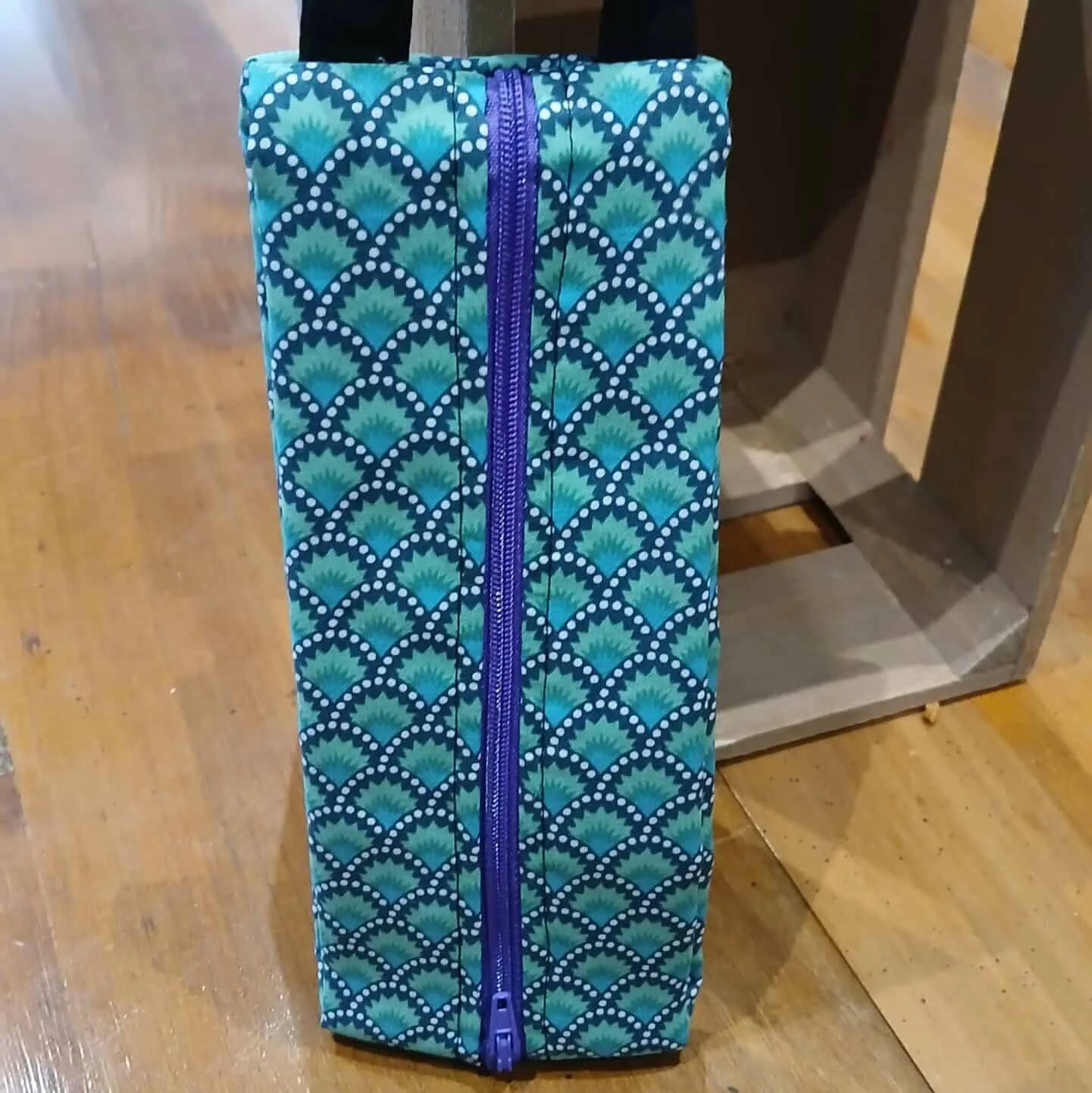 Trousse en tissu avec motifs éventails bleus et verts, fermeture éclair violette et anse pratique